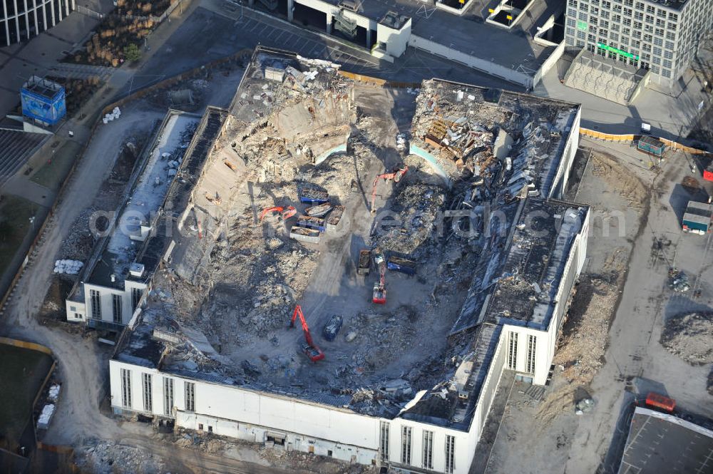 Aerial image Berlin - Blick auf die Abrißarbeiten an der ehemaligen Deutschlandhalle an der Jaffeystraße auf dem Messegelände in Charlottenburg. Abbruch-Bagger der Berliner Firma „ RWG1 “ setzten sie ihre tonnenschweren Kneifzangen in Betrieb und hackten sich in den Beton. Begonnen wurde mit dem Fassaden-Abriss an der Nordseite der Halle mit Abbruch-Bagger der Marke „ Liebherr “, Modelle 954 und 974. Sie wiegen 87 bis 140 Tonnen, haben bis zu 543 PS, nehmen die Fassade mit verschiedenen Greif- und Kneifbacken in die Zange. Der Abbruch soll bis März des Folgejahres beendet sein, um die nötige Baufreiheit für die Grundsteinlegung einer neuen Kongress- und Messehalle der Messe Berlin zu gewährleisten. Demolition work of the former Germany Halle Jaffeystraße on the fairgrounds in Charlottenburg.