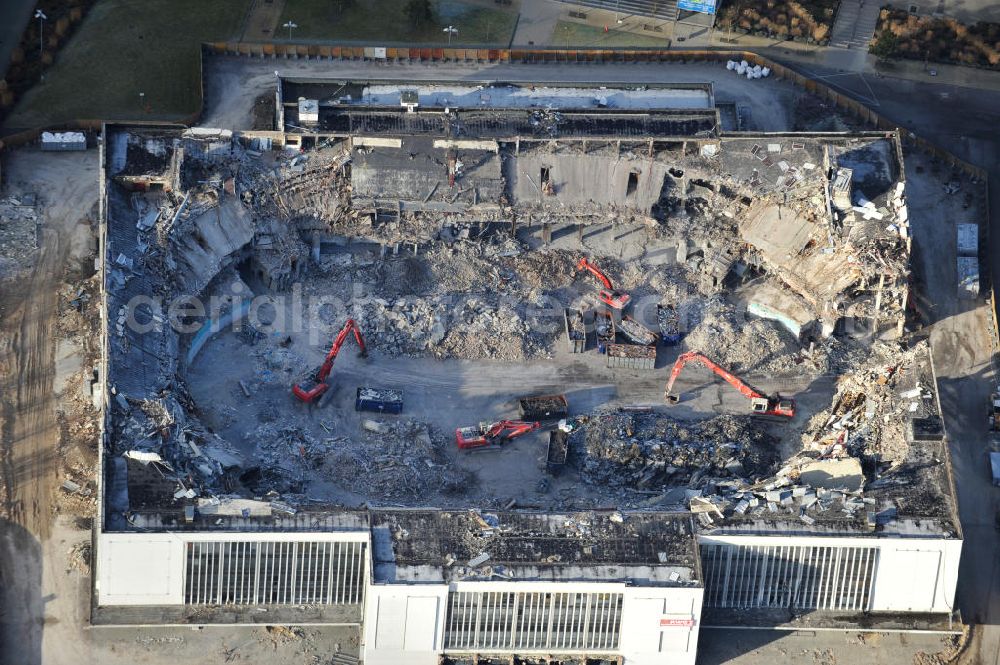 Berlin from above - Blick auf die Abrißarbeiten an der ehemaligen Deutschlandhalle an der Jaffeystraße auf dem Messegelände in Charlottenburg. Abbruch-Bagger der Berliner Firma „ RWG1 “ setzten sie ihre tonnenschweren Kneifzangen in Betrieb und hackten sich in den Beton. Begonnen wurde mit dem Fassaden-Abriss an der Nordseite der Halle mit Abbruch-Bagger der Marke „ Liebherr “, Modelle 954 und 974. Sie wiegen 87 bis 140 Tonnen, haben bis zu 543 PS, nehmen die Fassade mit verschiedenen Greif- und Kneifbacken in die Zange. Der Abbruch soll bis März des Folgejahres beendet sein, um die nötige Baufreiheit für die Grundsteinlegung einer neuen Kongress- und Messehalle der Messe Berlin zu gewährleisten. Demolition work of the former Germany Halle Jaffeystraße on the fairgrounds in Charlottenburg.