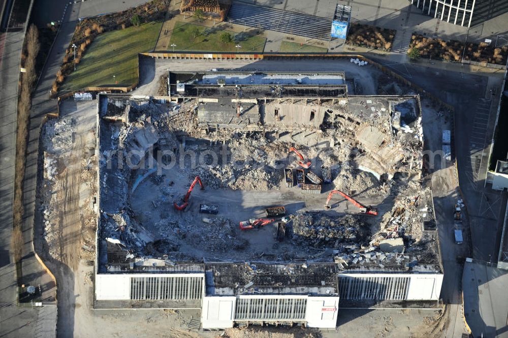 Berlin from above - Blick auf die Abrißarbeiten an der ehemaligen Deutschlandhalle an der Jaffeystraße auf dem Messegelände in Charlottenburg. Abbruch-Bagger der Berliner Firma „ RWG1 “ setzten sie ihre tonnenschweren Kneifzangen in Betrieb und hackten sich in den Beton. Begonnen wurde mit dem Fassaden-Abriss an der Nordseite der Halle mit Abbruch-Bagger der Marke „ Liebherr “, Modelle 954 und 974. Sie wiegen 87 bis 140 Tonnen, haben bis zu 543 PS, nehmen die Fassade mit verschiedenen Greif- und Kneifbacken in die Zange. Der Abbruch soll bis März des Folgejahres beendet sein, um die nötige Baufreiheit für die Grundsteinlegung einer neuen Kongress- und Messehalle der Messe Berlin zu gewährleisten. Demolition work of the former Germany Halle Jaffeystraße on the fairgrounds in Charlottenburg.