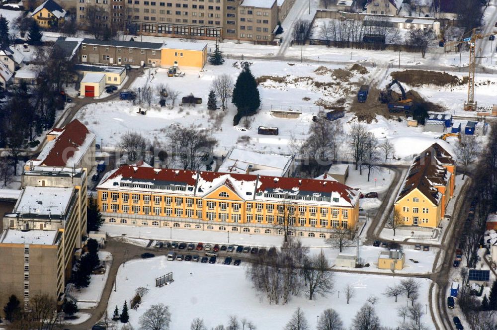 Berlin from the bird's eye view: Blick auf die winterlich verschneite Abrissfläche / den Rückbau vom Haus 9 und Haus 15 (Kesselhaus) auf dem Gelände des Vivantes Klinikum Hellersdorf. Look at the wintry, snowy surface on the site of the demolished Vivantes Klinikum Berlin - Hellersdorf - Genius Ingenieurbüro GmbH, Treskowallee 30, 10318 Berlin, Tel. +49(0)30 818584-0, Fax +49(0)30 818584-99, email: krebs@ibgenius.de