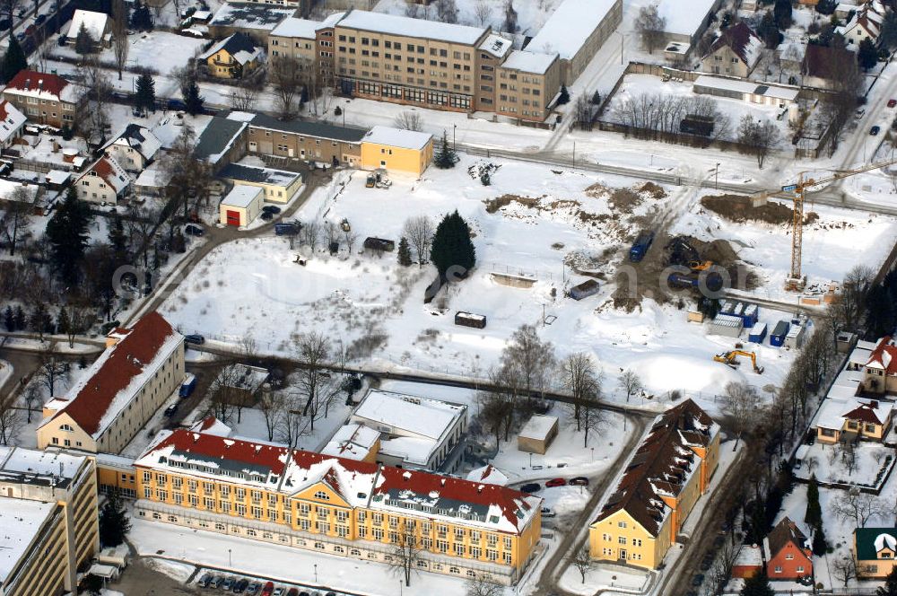 Aerial photograph Berlin - Blick auf die winterlich verschneite Abrissfläche / den Rückbau vom Haus 9 und Haus 15 (Kesselhaus) auf dem Gelände des Vivantes Klinikum Hellersdorf. Look at the wintry, snowy surface on the site of the demolished Vivantes Klinikum Berlin - Hellersdorf - Genius Ingenieurbüro GmbH, Treskowallee 30, 10318 Berlin, Tel. +49(0)30 818584-0, Fax +49(0)30 818584-99, email: krebs@ibgenius.de