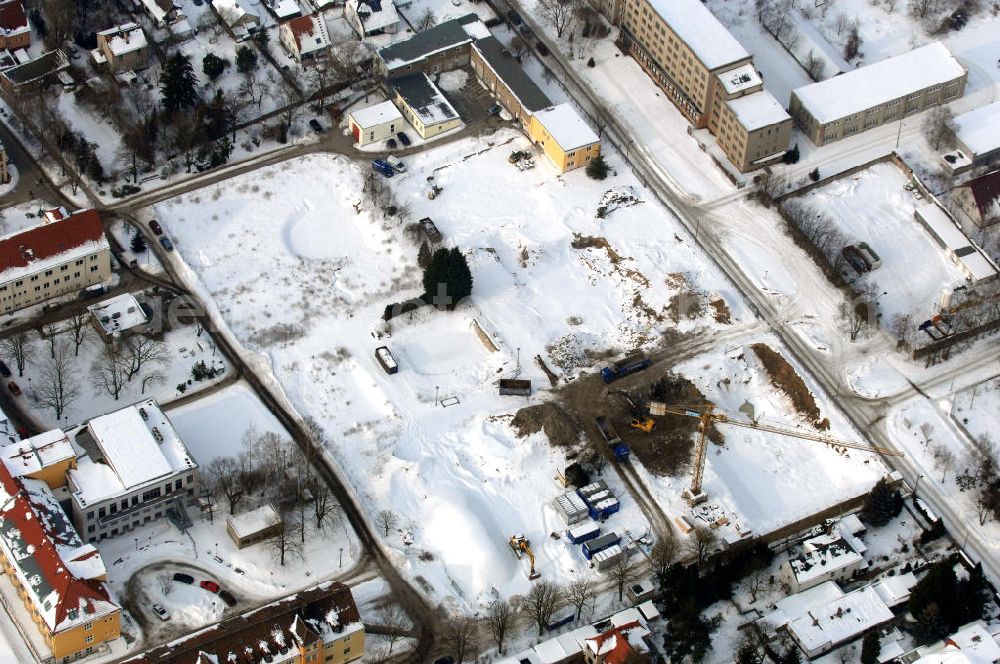 Berlin from the bird's eye view: Blick auf die winterlich verschneite Abrissfläche / den Rückbau vom Haus 9 und Haus 15 (Kesselhaus) auf dem Gelände des Vivantes Klinikum Hellersdorf. Look at the wintry, snowy surface on the site of the demolished Vivantes Klinikum Berlin - Hellersdorf - Genius Ingenieurbüro GmbH, Treskowallee 30, 10318 Berlin, Tel. +49(0)30 818584-0, Fax +49(0)30 818584-99, email: krebs@ibgenius.de