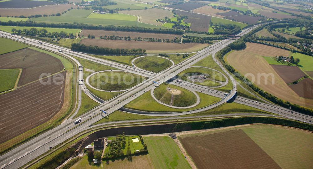 Aerial photograph Kamen - Blick auf das Autobahnkreuz Kamener Kreuz im Nordosten des Ruhrgebietes bei Kamen. Neu istalliert ist das ADAC-Denkmal , einer Skluptur aus acht Figuren , welche einen ausrangierten ADAC- Helikopter tragen. Die Kunstinstallation Gelbe Engel ist ein Werk des Kuenstler Alex Gockel. Rund 200.000 Fahrzeuge passieren täglich das Kreuz und somit hat dieses kunstwerk reale Chancen, zum meistbeachteten Kunstwerk Deutschlands zu werden.