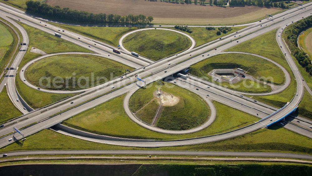 Kamen from the bird's eye view: Blick auf das Autobahnkreuz Kamener Kreuz im Nordosten des Ruhrgebietes bei Kamen. Neu istalliert ist das ADAC-Denkmal , einer Skluptur aus acht Figuren , welche einen ausrangierten ADAC- Helikopter tragen. Die Kunstinstallation Gelbe Engel ist ein Werk des Kuenstler Alex Gockel. Rund 200.000 Fahrzeuge passieren täglich das Kreuz und somit hat dieses kunstwerk reale Chancen, zum meistbeachteten Kunstwerk Deutschlands zu werden.