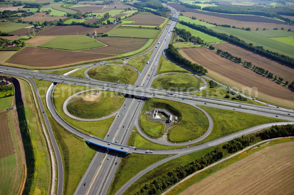 Aerial photograph Kamen - Blick auf das Autobahnkreuz Kamener Kreuz im Nordosten des Ruhrgebietes bei Kamen. Neu installiert ist das ADAC-Denkmal , einer Skluptur aus acht Figuren , welche einen ausrangierten ADAC- Helikopter tragen. Die Kunstinstallation Gelbe Engel ist ein Werk des Kuenstler Alex Gockel. Rund 200.000 Fahrzeuge passieren täglich das Kreuz und somit hat dieses kunstwerk reale Chancen, zum meistbeachteten Kunstwerk Deutschlands zu werden.