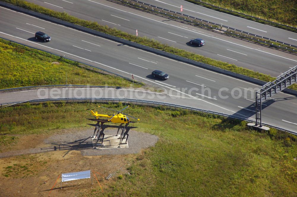 Kamen from above - Blick auf das Autobahnkreuz Kamener Kreuz im Nordosten des Ruhrgebietes bei Kamen. Neu installiert ist das ADAC-Denkmal , einer Skluptur aus acht Figuren , welche einen ausrangierten ADAC- Helikopter tragen. Die Kunstinstallation Gelbe Engel ist ein Werk des Kuenstler Alex Gockel. Rund 200.000 Fahrzeuge passieren täglich das Kreuz und somit hat dieses kunstwerk reale Chancen, zum meistbeachteten Kunstwerk Deutschlands zu werden.