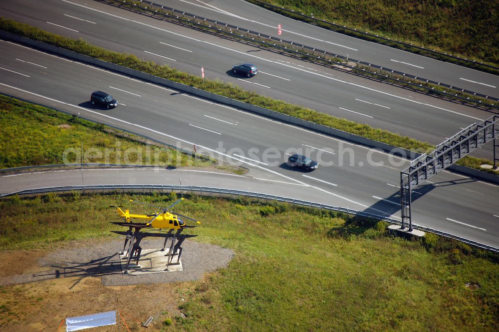 Kamen from the bird's eye view: Blick auf das Autobahnkreuz Kamener Kreuz im Nordosten des Ruhrgebietes bei Kamen. Neu installiert ist das ADAC-Denkmal , einer Skluptur aus acht Figuren , welche einen ausrangierten ADAC- Helikopter tragen. Die Kunstinstallation Gelbe Engel ist ein Werk des Kuenstler Alex Gockel. Rund 200.000 Fahrzeuge passieren täglich das Kreuz und somit hat dieses kunstwerk reale Chancen, zum meistbeachteten Kunstwerk Deutschlands zu werden.