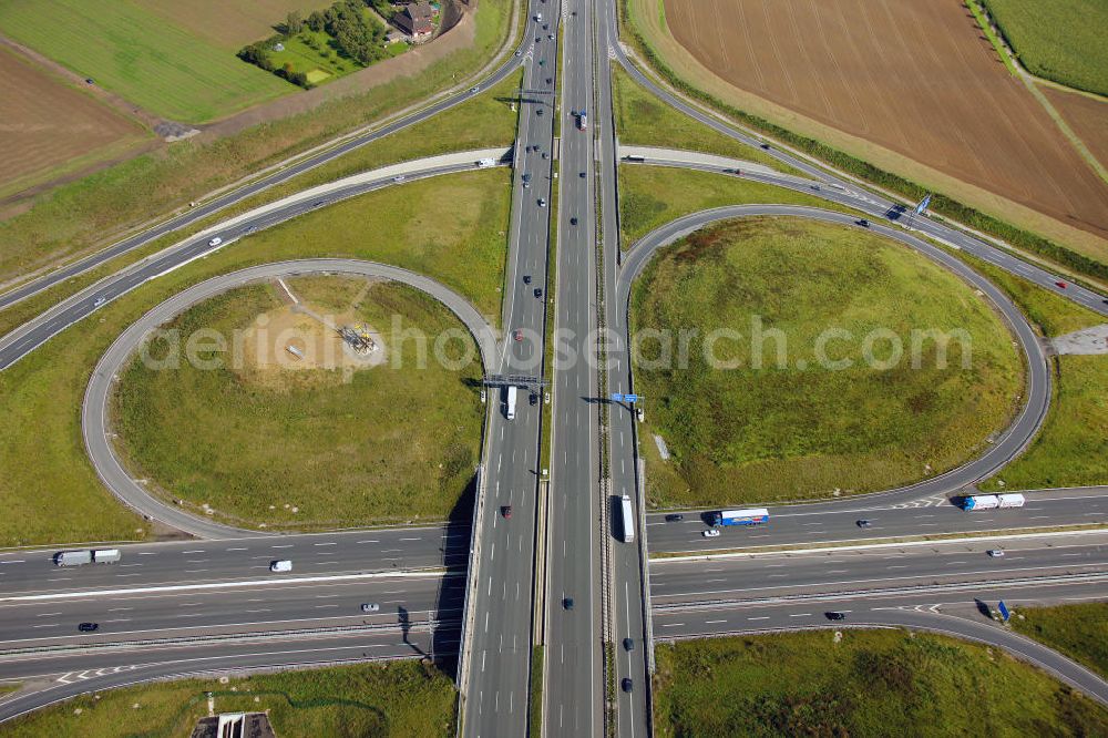 Aerial photograph Kamen - Blick auf das Autobahnkreuz Kamener Kreuz im Nordosten des Ruhrgebietes bei Kamen. Neu installiert ist das ADAC-Denkmal , einer Skluptur aus acht Figuren , welche einen ausrangierten ADAC- Helikopter tragen. Die Kunstinstallation Gelbe Engel ist ein Werk des Kuenstler Alex Gockel. Rund 200.000 Fahrzeuge passieren täglich das Kreuz und somit hat dieses kunstwerk reale Chancen, zum meistbeachteten Kunstwerk Deutschlands zu werden.