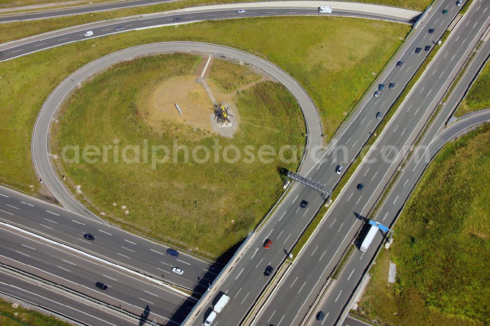 Kamen from the bird's eye view: Blick auf das Autobahnkreuz Kamener Kreuz im Nordosten des Ruhrgebietes bei Kamen. Neu installiert ist das ADAC-Denkmal , einer Skluptur aus acht Figuren , welche einen ausrangierten ADAC- Helikopter tragen. Die Kunstinstallation Gelbe Engel ist ein Werk des Kuenstler Alex Gockel. Rund 200.000 Fahrzeuge passieren täglich das Kreuz und somit hat dieses kunstwerk reale Chancen, zum meistbeachteten Kunstwerk Deutschlands zu werden.