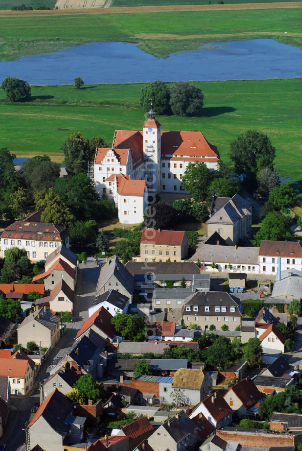 Aerial image Pretzsch - Blick auf das Schloss Pretzsch an der Elbe. Pretzsch liegt am Westufer der Elbe am nordwestlichen Rand des Naturparkes Dübener Heide. Stadt und Schloss liegen, von Hochwasserschutzdeichen umgeben, auf dem westlichen Elbufer. An der Stelle des Schlosses, das 1570 - 74 von dem damaligen Besitzer der alten gotischen Burganlage, Hans von Löser, erbaut wurde, stand bereits im Jahre 981 ein Burgward. Damit gehört das jetzige Schloss zu den ältesten Befestigungsanlagen im Bereich der Dübener Heide. Als Sachsen nach dem Befreiungskrieg gegen Napoleon 1815 Teile seines Landes an Preußen abgeben musste, kam auch Pretzsch in preußischen Besitz. Das Schloss wurde dem „Großen Potsdamschen Militärwaisenhaus“ übergeben. 1829 kamen die ersten Waisenkinder in das Schloss. Nach dem zweiten Weltkrieg wurde das Schloss wieder ein Kinderheim. In der heutigen Adolf-Reichwein-Schule - Schloss Pretzsch werden seit 1960 Kinder und Jugendliche unterrichtet. Seit 1992 ist die Schule eine Sonderschule mit Ausgleichsklassen. Kontakt: Adolf-Reichwein-Schule - Schloss Pretzsch, Schlossbezirk 1, 06909 Pretzsch, Tel.: 034926/57166, E-Mail: adolf-reichwein-schule-pretzsc@t-online.de,