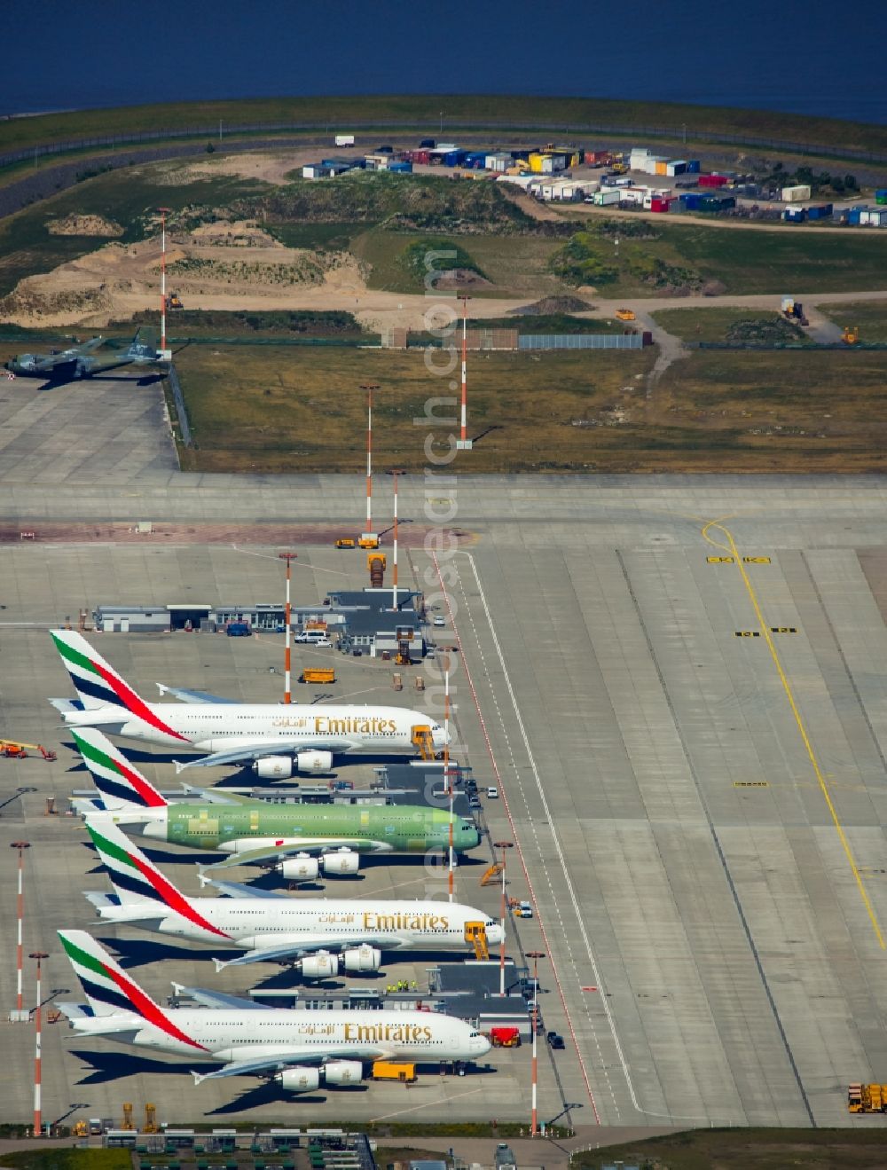 Hamburg from the bird's eye view: Airbus airplanes of Emirates Airlines on the works facilities and area of Finkenwerder in Hamburg in Germany. The former Hamburger Flugzeugbau works include an Airbus production site with an airplane. Several Airbus planes and modells are being constructed here