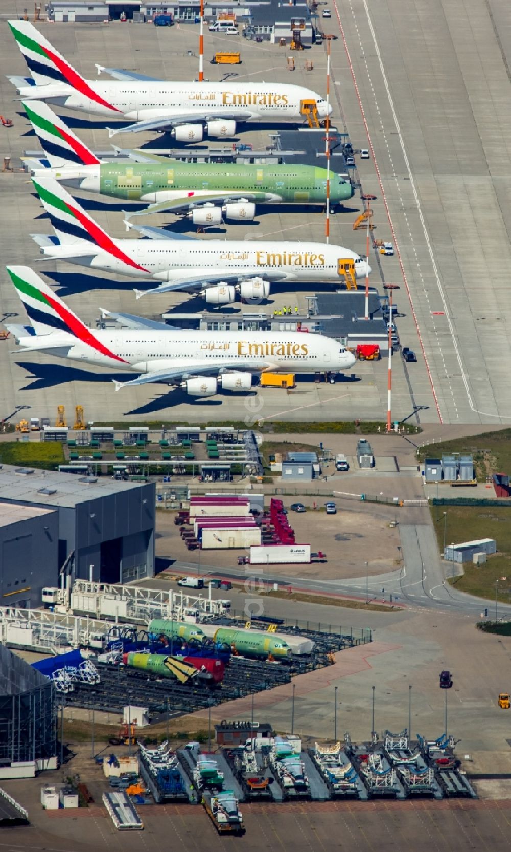 Aerial image Hamburg - Airbus airplanes of Emirates Airlines on the works facilities and area of Finkenwerder in Hamburg in Germany. The former Hamburger Flugzeugbau works include an Airbus production site with an airplane. Several Airbus planes and modells are being constructed here