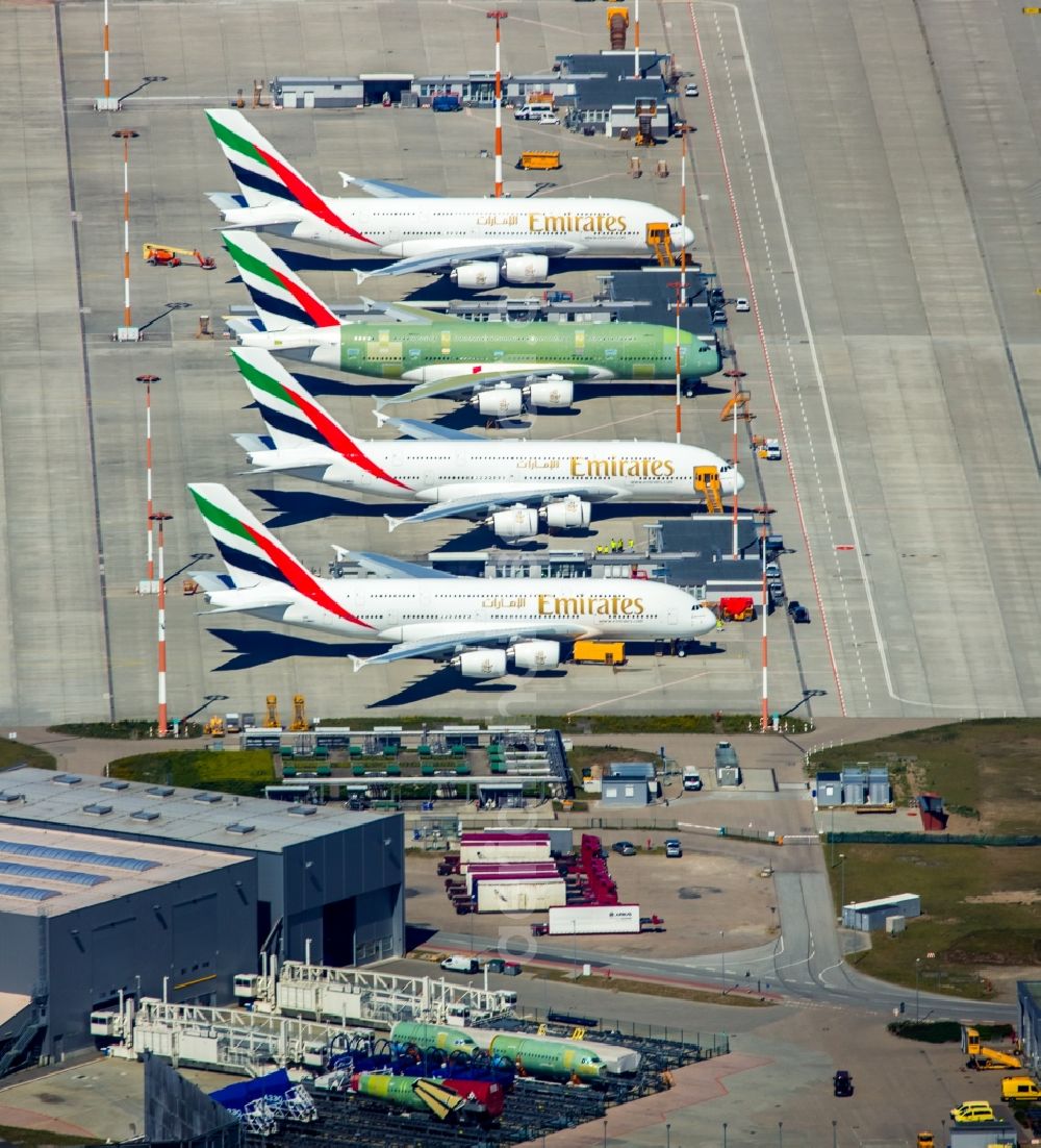 Hamburg from above - Airbus airplanes of Emirates Airlines on the works facilities and area of Finkenwerder in Hamburg in Germany. The former Hamburger Flugzeugbau works include an Airbus production site with an airplane. Several Airbus planes and modells are being constructed here