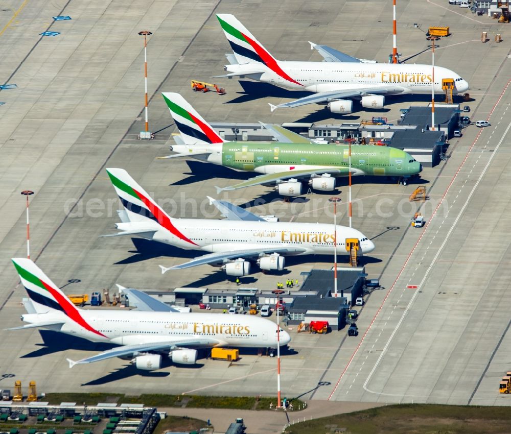 Hamburg from the bird's eye view: Airbus airplanes of Emirates Airlines on the works facilities and area of Finkenwerder in Hamburg in Germany. The former Hamburger Flugzeugbau works include an Airbus production site with an airplane. Several Airbus planes and modells are being constructed here