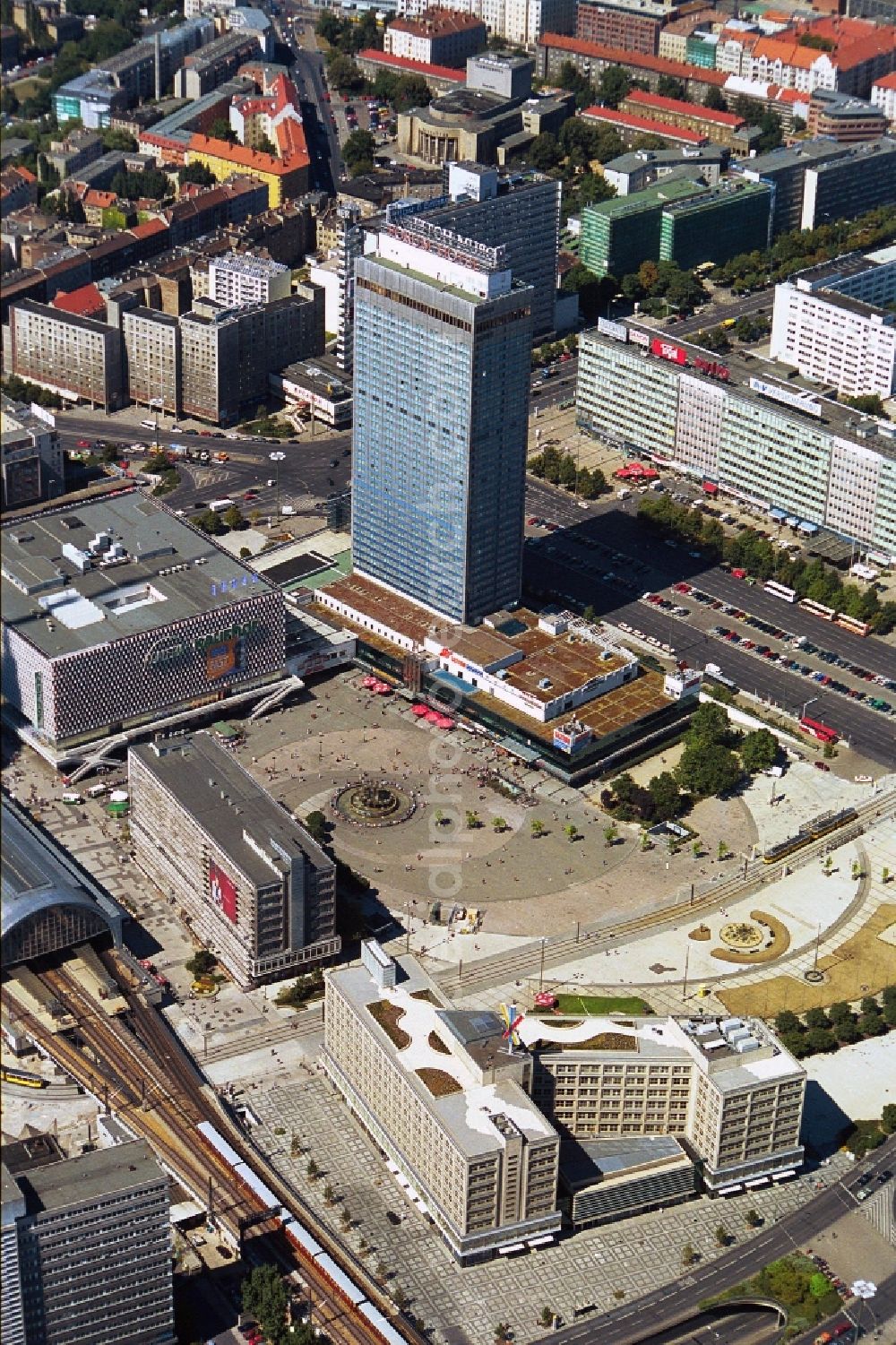 Aerial photograph Berlin - The Alexanderplatz in Berlin-Mitte end of 1990 years with the S-Bahn station, the department store Galeria Kaufhof and the Forum Hotel. Even the appearance corresponds to the development plans of the communist era. The Forum hotel was designed by the renowned architect Roland Korn and Hans Erich Bogatzky