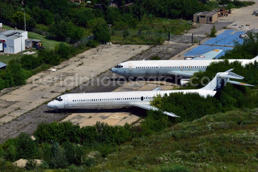 Bukarest from above - Old airplanes on Baneasa International Airport. The airliners are standing between trees and greens at the airport's western end. The airport is located in the industrial and commercial area of the city