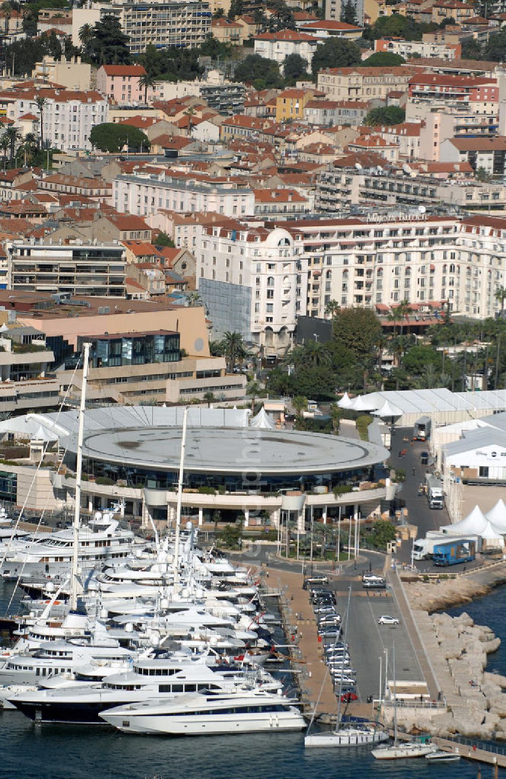 Cannes from above - Blick auf den Alter Hafen und das Palais de Festivals et des Congrès von Cannes in Frankreich. Der Alte Hafen von Cannes, der 1883 gebaut wurde, hat sich noch ein provenzialisches Aussehen bewahrt und ist der Standort des berühmten Palais de Festivals. In diesem Gebäude finden jedes Jahr die Internationalen Filmfestspiele statt. Kontakt Palais: Palais des Festivals et des Congrès de Cannes, 06403 Cannes Cedex, Tel. +33(0)493 390101, Fax *33(0)493 993734; Kontakt Touristinfo: Office du Tourisme, BP 272, 06403 Cannes Cedex, Tel. +33(0)492 99842 2, Fax +33(0)492 99842 3, Email: tourisme@semec.com