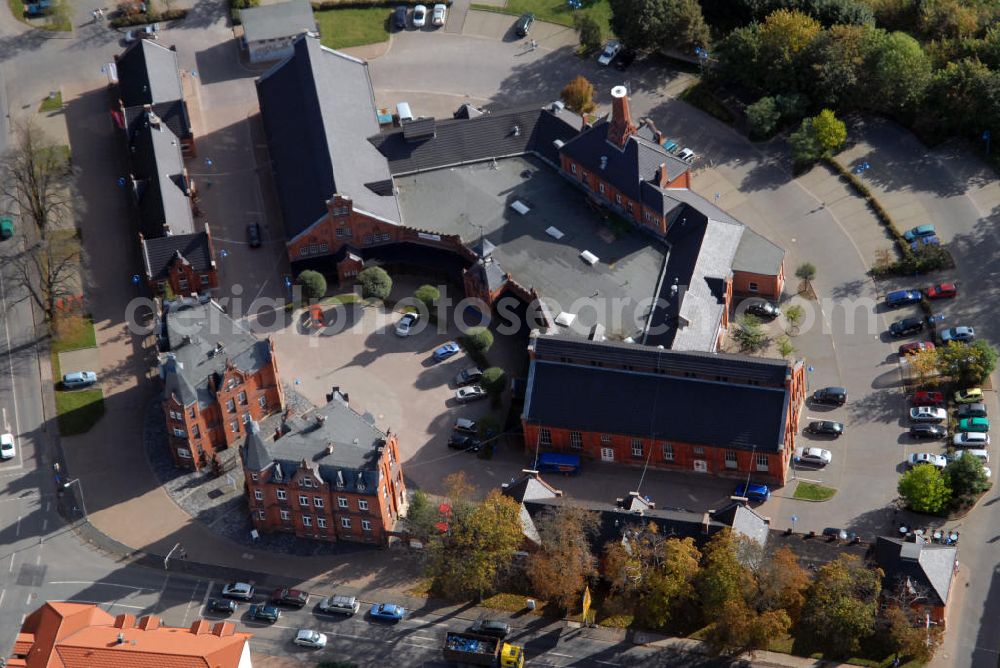 Gotha from the bird's eye view: Auf dem ca. 23.870 m² große Grundstück befindet sich ein Einzeldenkmal, erbaut im Jahre 1890-1891 vom Architekten Conrad Schaller. Das ehemals als Schlachthof genutzte Gebäudeensemble wurde in den Jahren 1993/1994 zu einem multifunktionalen Zentrum mit Handels- und Dienstleistungseinrichtungen umgebaut. Das eigentliche Schlachthaus wurde in Absprache mit dem Denkmalschutz und nach Renovierung der Altfassade als Geschäftscenter mit Klein- und Großläden umgebaut. Die ehemaligen Stallungsgebäude entlang der Parkstraße und der Ülleber Straße wurden nach Teilabrissen, nachträglichen An- und Ausbauten und Fassadenrenovierungen zu Kleinladenzeilen umgebaut. Das alte Schlachthof-Gelände liegt westlich des Stadtzentrums - unweit vom Schlosspark und ist eine der architektonisch attraktivsten Straßenzüge in Gotha.