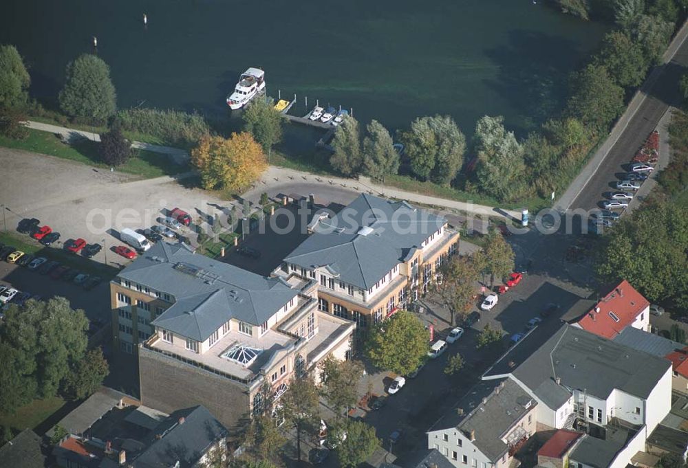 Aerial photograph Werder ( Brandenburg ) - Das »Alte Brauhaus Werder« wurde 1887 erbaut und steht unter Denkmalschutz. 1995 wurde es aufgestockt und um einen Anbau erweitert. Beide Bauteile bilden ein Ensemble, das sich an der Hauptgeschäftsstraße befindet und in der Innenstadt von Werder einen architektonischen Schwerpunkt bildet. HVB Immobilien AG Der Standort unmittelbar am Ufer der Havel und kurz vor der Brücke in die historische Altstadt gehört zu den exponierten Lagen vor Ort.