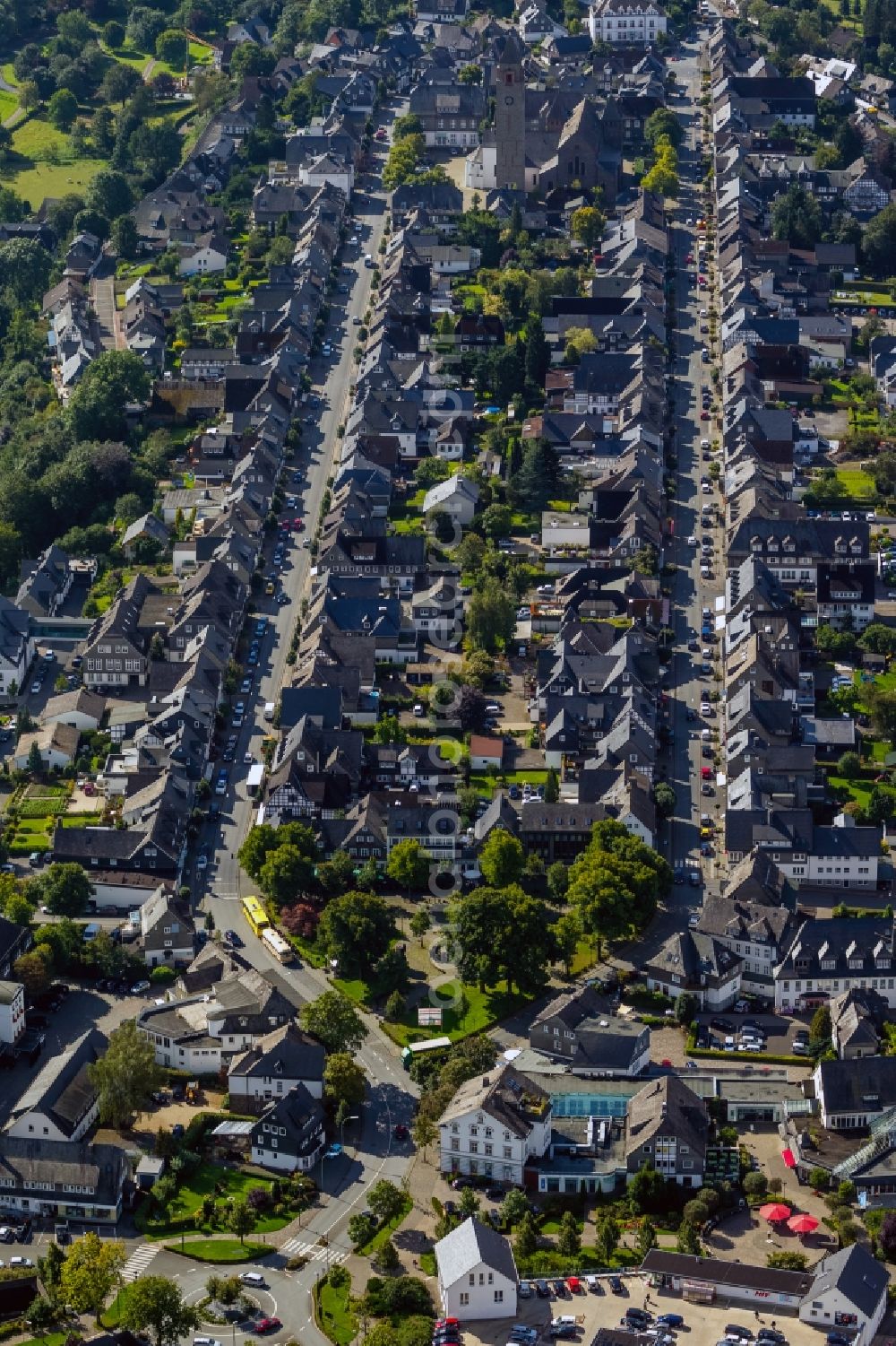 Aerial image Schmallenberg - View of the course of the streets Oststrasse and Weststrasse through the historical city centre of Schmallenberg in the state North Rhine-Westphalia. They are lined with grey houses and at the end of the street the church St.-Alexan der is visible