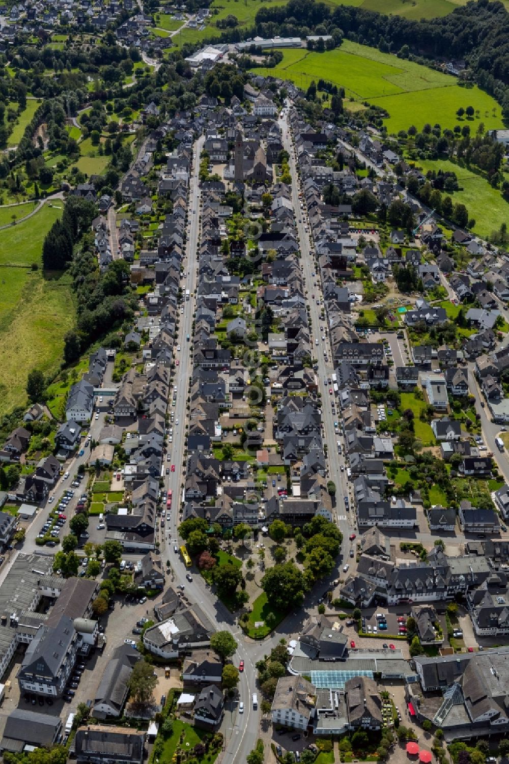 Aerial image Schmallenberg - View of the course of the streets Oststrasse and Weststrasse through the historical city centre of Schmallenberg in the state North Rhine-Westphalia. They are lined with grey houses and at the end of the street the church St.-Alexan der is visible