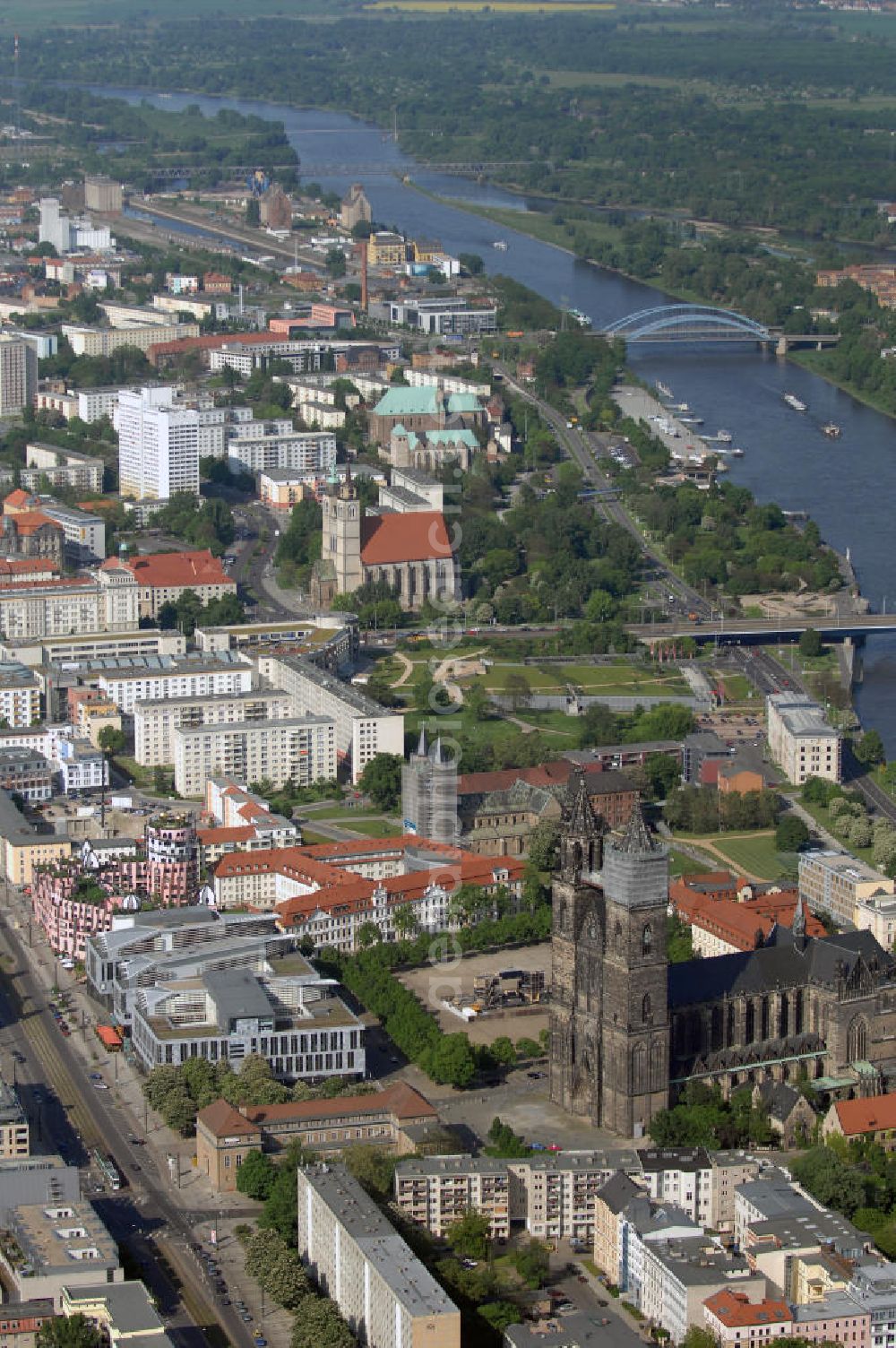 Aerial image Magdeburg - Blick auf die Altstadt westlich der Elbe in Magdeburg. Das Bild der Altstadt wurde durch die fast vollständige Zerstörung im Zweiten Weltkrieg mit seinen zahlreichen Neubauten geprägt. Eine der bedeutendsten Magdeburger Straßen verläuft durch die gesamte Altstadt. Die Wohn - und Geschäftsstraße Breiter Weg, die im Jahre 1207 bereits existierte und mit reichlich Sehenswürdigkeiten bestückt ist. Neben der St. Sebastian Kirche, dem erst im Oktober 2005 eingeweihten Hundertwasserhaus und dem Dom zu Magdeburg ist der Brete Weg ein beliebtes Ziel für Touristen. Mit dem Blick über die Elbe ist ebenfalls der westliche Teil des anlässlich zur Bundesgartenschau 1999 entstandene Elbauenpark zu sehen. Kontakt: Touristeninformation Magdeburg, Ernst - Reuter - Allee 12, 39104 Magdeburg, Tel. +49(0)391 19433, Fax +49(0)391 540 4930, Email: info@magdeburg-tourist.de