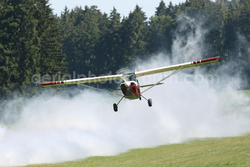 Bad Dietzenbach from the bird's eye view: Flugzeug / Kleinflugzeug vom Typ American Champion Aircraft Champ 7FC, bei einem tiefen Überflug auf dem Flugplatz Bad Dietzenbach EDPB umgangssprachlich das Berneck. Small aircraft over the Bad Dietzenbach airfield.