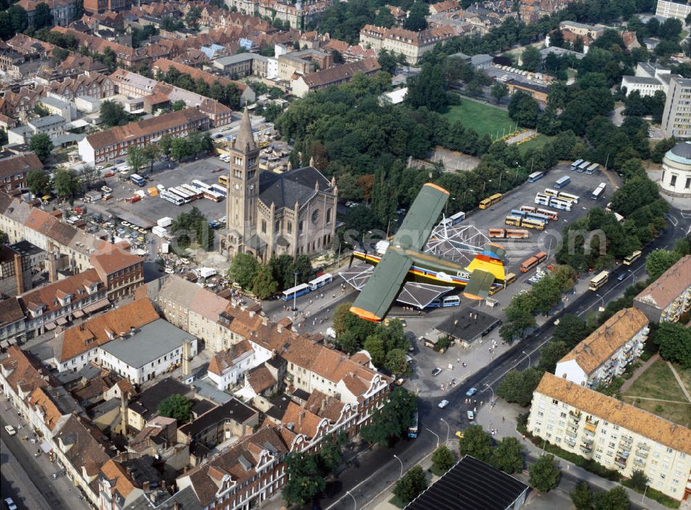 Potsdam from the bird's eye view: Blick auf eine Antonow AN-2 der Interflug Air Touristik über Potsdams historische Innenstadt. Unter dem Doppeldecker Typ STOL-Mehrzweckflugzeug erstrecken sich Wohngebäude, die katholischen Propsteikirche St. Peter und Paul und der Bassinplatz mit Busbahnhof. View of an Antonov AN-2 of the Interflug Air Touristik above Potsdam's historical city center with residential buildings, the Catholic Deanery Church of St. Peter and Paul and the Bassinplatz with the bus station.