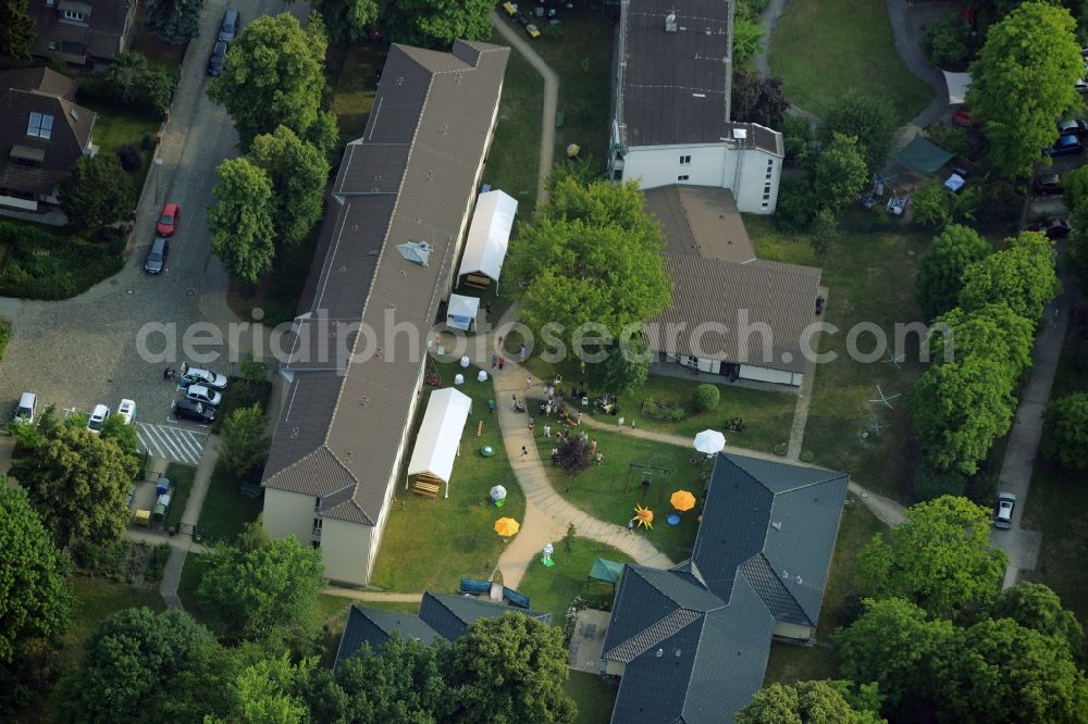 Berlin from the bird's eye view: Compound and building complex of the residential home Mentzelstrasse of the Sozialstiftung Koepenick in Berlin in Germany. The compound consists of several buildings, a garden and park. A party is taking place with stands