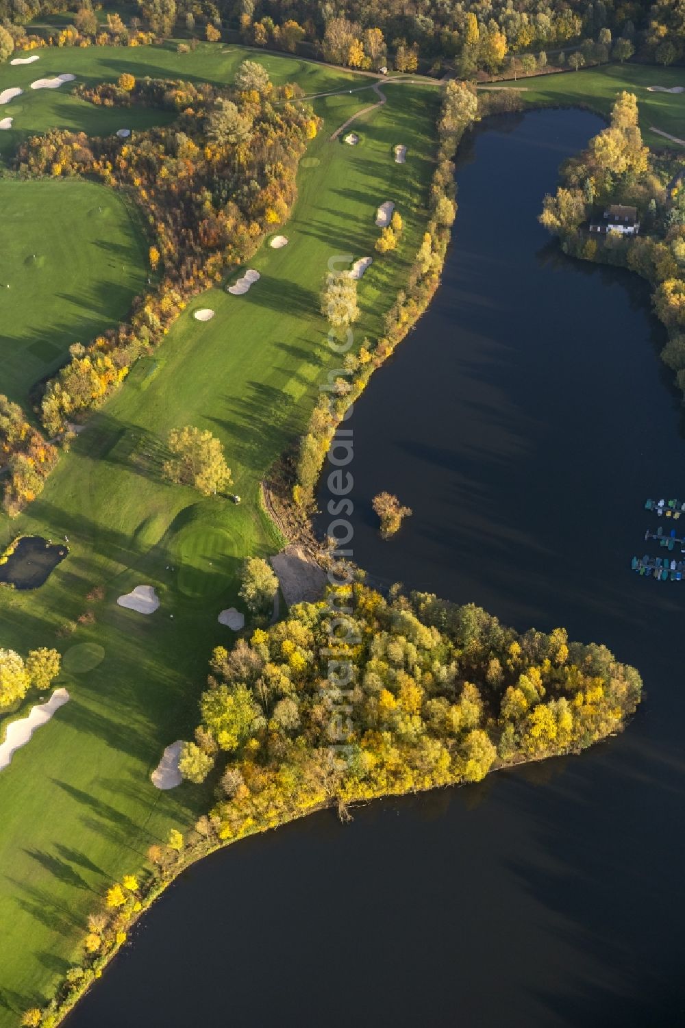 Duisburg from above - View of the autumnal golf course of the club Golf And More at Altenbrucher Damm in Duisburg - Huckingen in the state North Rhine-Westphalia. The golf links with its fairway, rough, bunkering and putting green is located directly on the banks of the lake Remberger See in the south of the Ruhr region city Duisburg