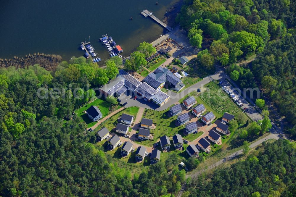 Berlin from above - Complex of the Ruebezahl on the shores of the Mueggelsee in Berlin in Germany. The compound includes a restaurant, a boat renting place and a holiday house complex and is located on the shores of the lake in the nature protection area of Koepenick