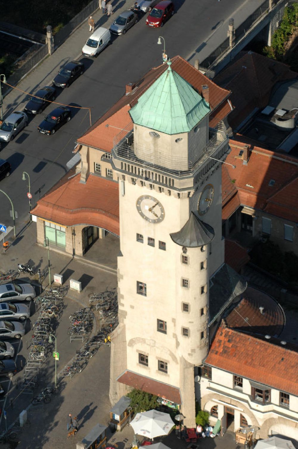 Aerial image Berlin - Frohnau - Blick auf den das Areal am S-Bahnhof Berlin - Frohnau am Ludolfingerplatz , Frohnauer Brücke. Der Casinoturm wurde zwischen 1909 und 1910 als 30 Meter hohes Wahrzeichen des Ortsteils nach einem Entwurf der Architekten Gustav Hart und Alfred Lesser erbaut. Der balkonartige Umgang unterhalb der Turmspitze in einer Höhe von 26,5 Metern ist als Aussichtsplattform gestaltet. Das Bahnhofsgebäude mit dem tief gelegenen Bahnsteig ließ die Eisenbahndirektion Berlin 1908–1910 ebenfalls nach einem Entwurf der Architektengemeinschaft Gustav Hart & Alfred Lesser errichten. Beim Bau der Berliner Mauer 1961 wurde die S-Bahn zwischen den Bahnhöfen Frohnau und Hohen Neuendorf stillgelegt und erst am 31. Mai 1992 wieder eröffnet.