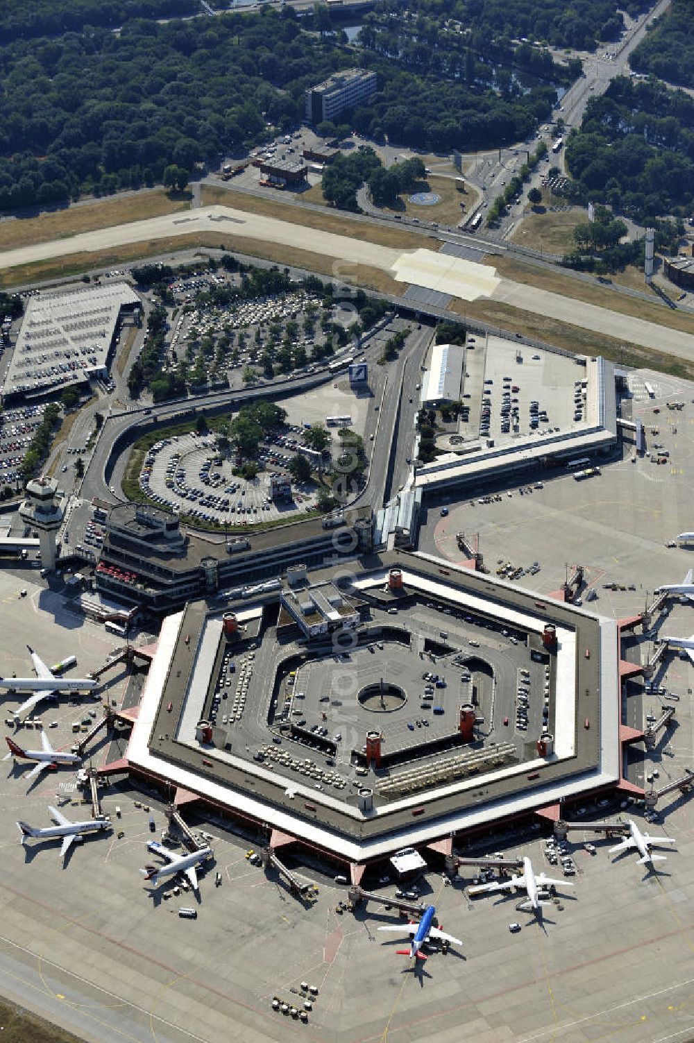 Aerial photograph Berlin - Blick auf das Areal des Flughafen Berlin- Tegel mit den beiden Start- und Landebahnen. Am Abfertigungsterminal stehen Flugzeuge der DELTA , AIR Berlin und BRITISH AIRWAYS. View of the area of the airport Berlin-Tegel with the two runways. On the Terminal stand aircraft - operated by DELTA, AIR BERLIN and BRITISH AIRWAYS.