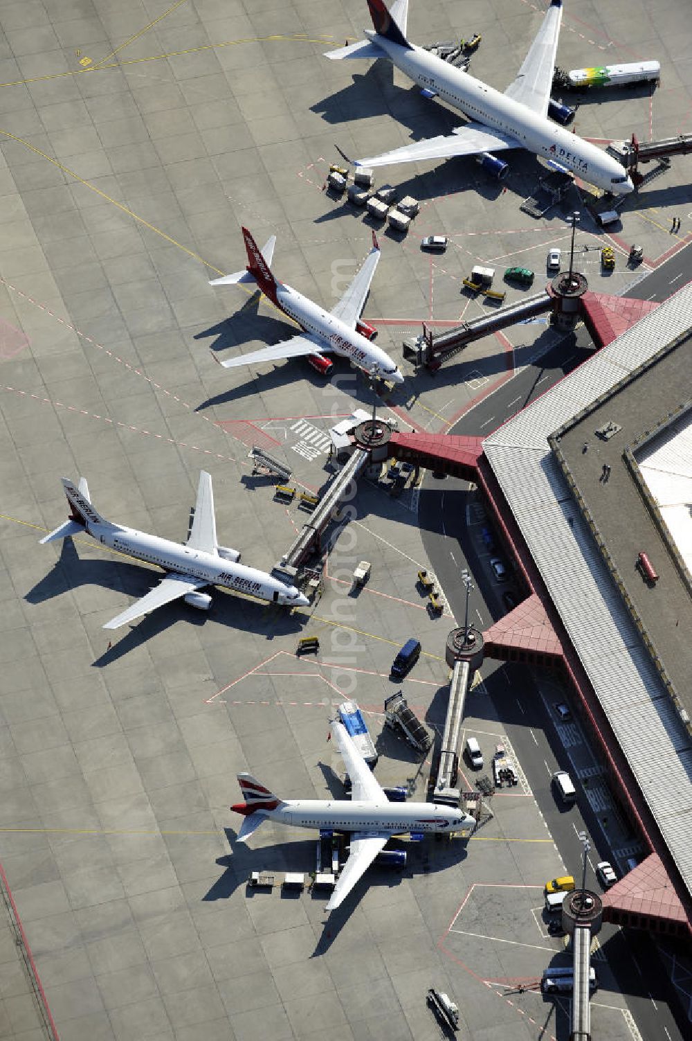 Aerial image Berlin - Blick auf das Areal des Flughafen Berlin- Tegel mit den beiden Start- und Landebahnen. Am Abfertigungsterminal stehen Flugzeuge der DELTA , AIR Berlin und BRITISH AIRWAYS. View of the area of the airport Berlin-Tegel with the two runways. On the Terminal stand aircraft - operated by DELTA, AIR BERLIN and BRITISH AIRWAYS.