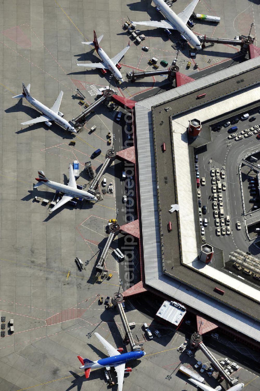 Aerial photograph Berlin - Blick auf das Areal des Flughafen Berlin- Tegel mit den beiden Start- und Landebahnen. Am Abfertigungsterminal stehen Flugzeuge der DELTA , AIR Berlin und BRITISH AIRWAYS. View of the area of the airport Berlin-Tegel with the two runways. On the Terminal stand aircraft - operated by DELTA, AIR BERLIN and BRITISH AIRWAYS.