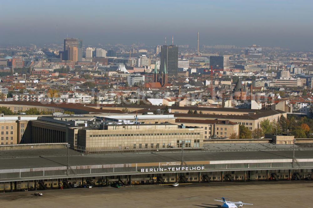 Aerial photograph Berlin - Blick auf das Areal des historischen Flughafens Berlin-Tempelhof. Die Klage der Fluggesellschaften gegen den neuen Schließungsbescheid vom August 2006, der das Ende der Flugbetriebes für Oktober 2007 vorsah, wurde am 19. und 21. Dezember 2006 vor dem OVG in Berlin verhandelt. Ein vom OVG vorgeschlagener Vergleich zur Anerkennung eines auf Oktober 2008 neu datierten Schließungsbescheides scheiterte an der fehlenden Zustimmung der meisten klagenden Luftfahrtunternehmen. Der Berliner Senat griff den Vergleich des OVG auf und änderte nochmals den Bescheid zum Widerruf der Betriebserlaubnis für den Flughafen Tempelhof, der nun als Datum für die Schließung den 31. Oktober 2008 vorsieht.Am 12. Februar 2007 bestätigte das Oberverwaltungsgericht Berlin-Brandenburg die Rechtmäßigkeit des Schließungsbescheides des Berliner Senats