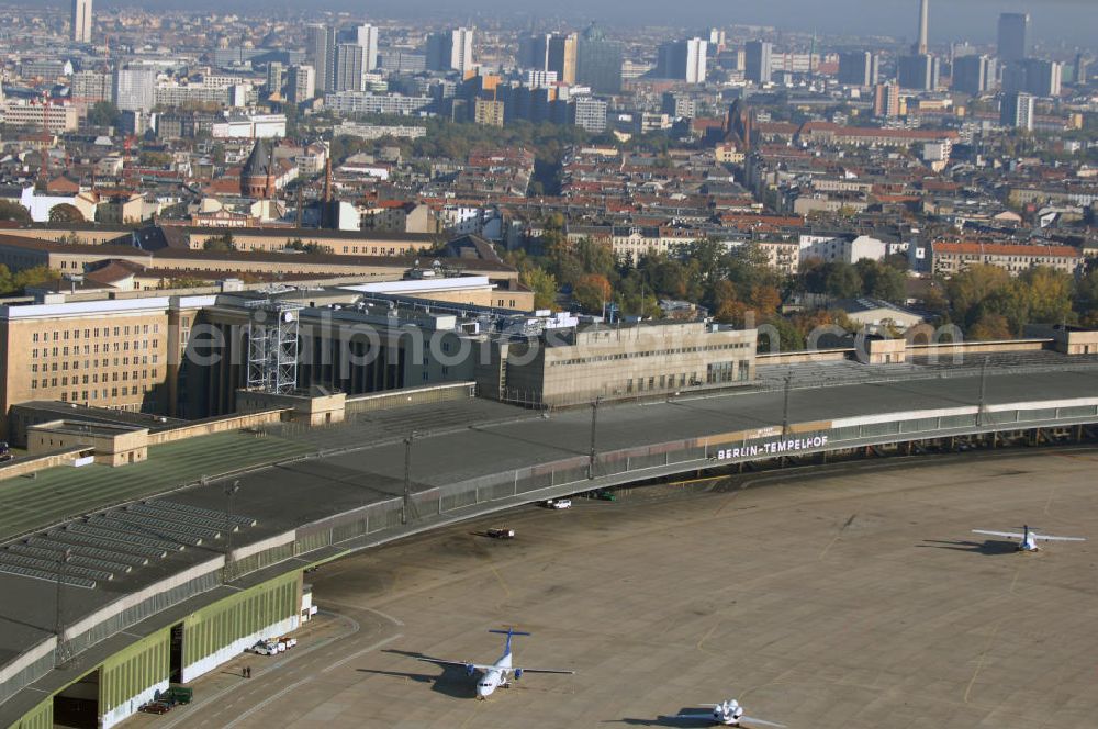 Aerial photograph Berlin - Blick auf das Areal des historischen Flughafens Berlin-Tempelhof. Die Klage der Fluggesellschaften gegen den neuen Schließungsbescheid vom August 2006, der das Ende der Flugbetriebes für Oktober 2007 vorsah, wurde am 19. und 21. Dezember 2006 vor dem OVG in Berlin verhandelt. Ein vom OVG vorgeschlagener Vergleich zur Anerkennung eines auf Oktober 2008 neu datierten Schließungsbescheides scheiterte an der fehlenden Zustimmung der meisten klagenden Luftfahrtunternehmen. Der Berliner Senat griff den Vergleich des OVG auf und änderte nochmals den Bescheid zum Widerruf der Betriebserlaubnis für den Flughafen Tempelhof, der nun als Datum für die Schließung den 31. Oktober 2008 vorsieht.Am 12. Februar 2007 bestätigte das Oberverwaltungsgericht Berlin-Brandenburg die Rechtmäßigkeit des Schließungsbescheides des Berliner Senats