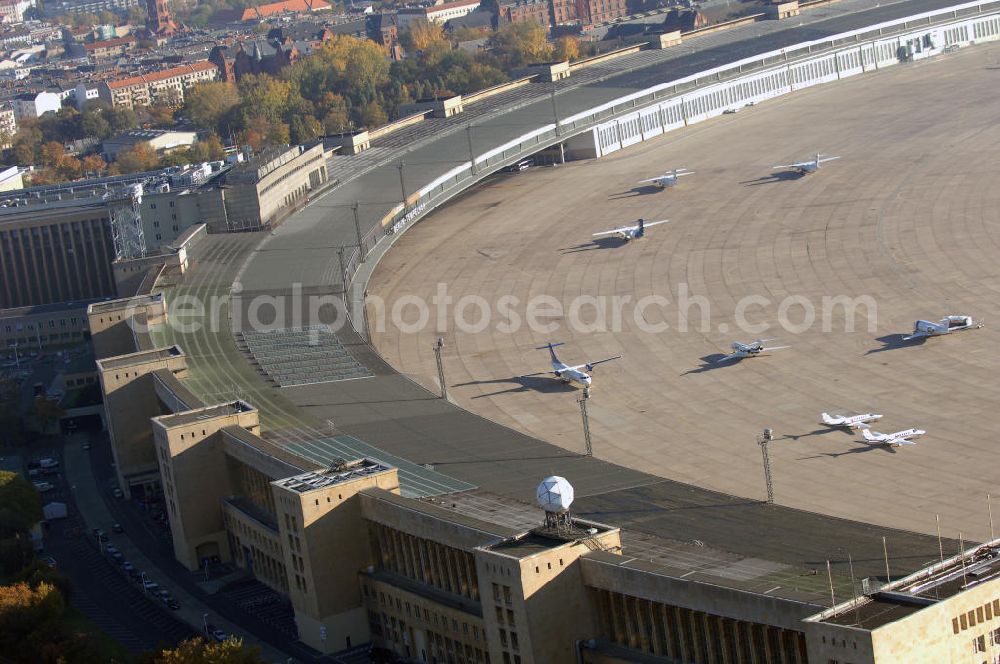 Aerial photograph Berlin - Blick auf das Areal des historischen Flughafens Berlin-Tempelhof. Die Klage der Fluggesellschaften gegen den neuen Schließungsbescheid vom August 2006, der das Ende der Flugbetriebes für Oktober 2007 vorsah, wurde am 19. und 21. Dezember 2006 vor dem OVG in Berlin verhandelt. Ein vom OVG vorgeschlagener Vergleich zur Anerkennung eines auf Oktober 2008 neu datierten Schließungsbescheides scheiterte an der fehlenden Zustimmung der meisten klagenden Luftfahrtunternehmen. Der Berliner Senat griff den Vergleich des OVG auf und änderte nochmals den Bescheid zum Widerruf der Betriebserlaubnis für den Flughafen Tempelhof, der nun als Datum für die Schließung den 31. Oktober 2008 vorsieht.Am 12. Februar 2007 bestätigte das Oberverwaltungsgericht Berlin-Brandenburg die Rechtmäßigkeit des Schließungsbescheides des Berliner Senats