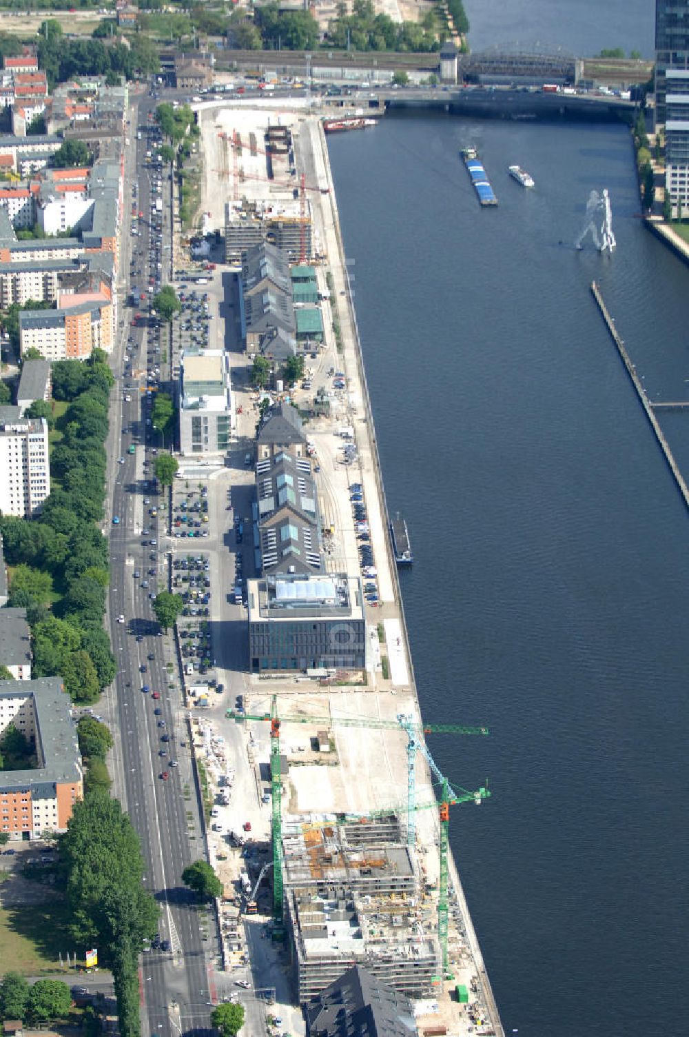 Aerial photograph Berlin - Blick auf das Areal Mediaspree, im Bereich des früheren Osthafens der BEHALA. Es ist eines der größten Investorenprojekte in Berlin und strebt die Ansiedlung von Kommunikations- und Medienunternehmen entlang eines Teils des Spreeufers und eine diesem Bereich entsprechende Umstrukturierung an. Auf größtenteils bislang un- oder zwischengenutzten Grundstücken sollen Bürogebäude, Lofts, Hotels und an dere Neubauten entstehen. Die Planungen stammen überwiegend aus den 1990er Jahren, wurden aber wegen der damals schlechten wirtschaftlichen Lage nur zum Teil umgesetzt. Die Initiatoren sehen in dem Projekt eine große Chance für den Osten Berlins.