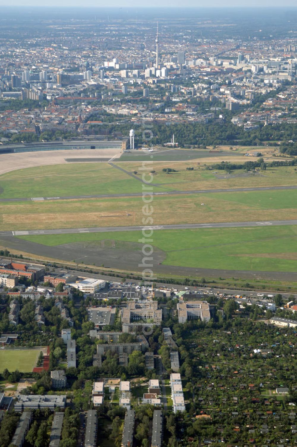 Berlin from the bird's eye view: Blick auf das Areal des stillgelegten Flughafen Berlin - Tempelhof mit den beiden Start- und Landebahnen. Neben gelegentlichen Events wie Konzerten und Messen ist das Gelände weitestgehend dem stillen Verfall preisgegeben. Noch sind alle luftverkehrsmäßigen Leit- und Befeuerungsanlagen intakt, aber lokalpolitische Erwägungen zwangen zur Stillegung dieses geschichtsträchtigen Flughafen.