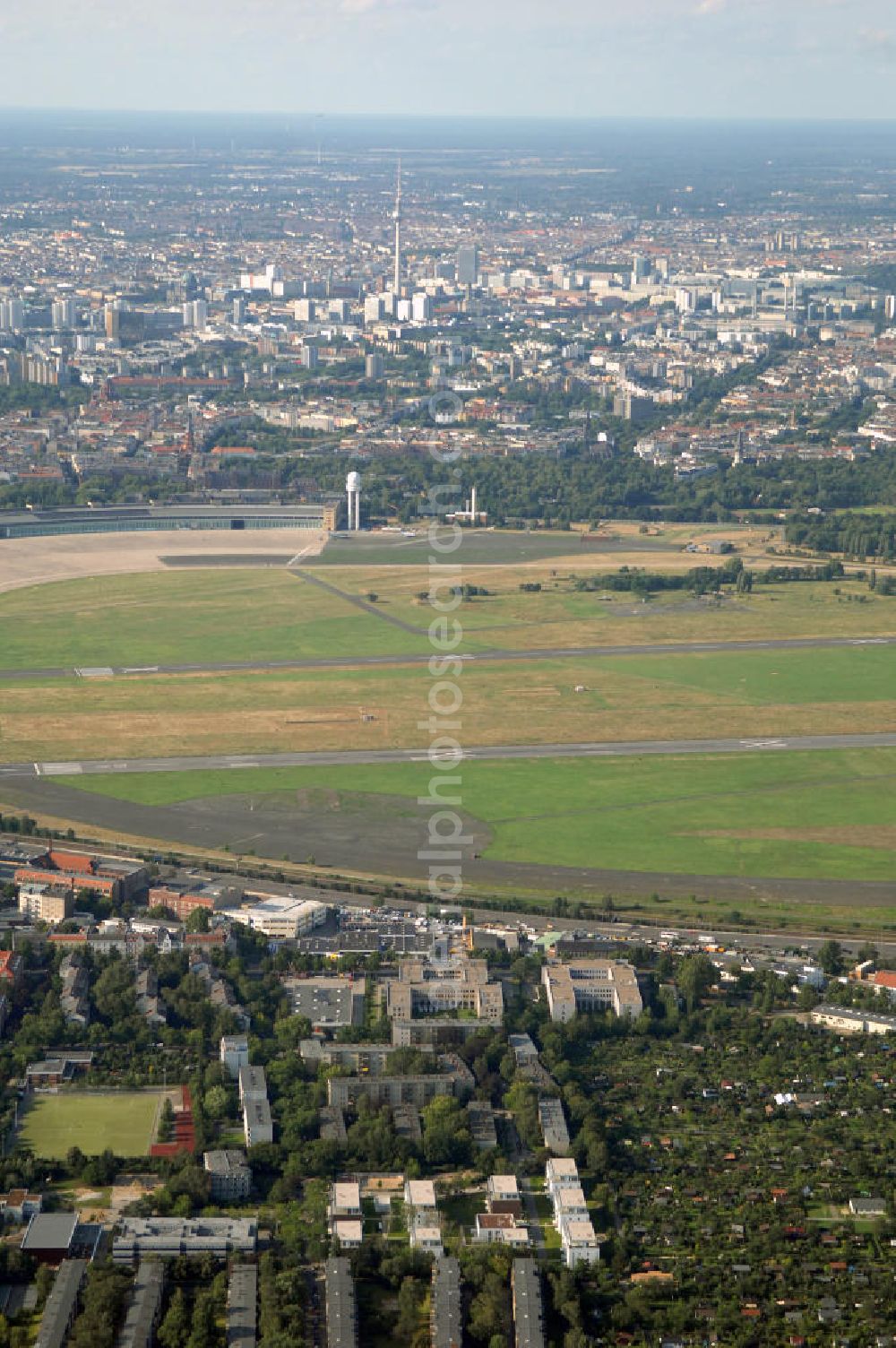 Aerial photograph Berlin - Blick auf das Areal des stillgelegten Flughafen Berlin - Tempelhof mit den beiden Start- und Landebahnen. Neben gelegentlichen Events wie Konzerten und Messen ist das Gelände weitestgehend dem stillen Verfall preisgegeben. Noch sind alle luftverkehrsmäßigen Leit- und Befeuerungsanlagen intakt, aber lokalpolitische Erwägungen zwangen zur Stillegung dieses geschichtsträchtigen Flughafen.