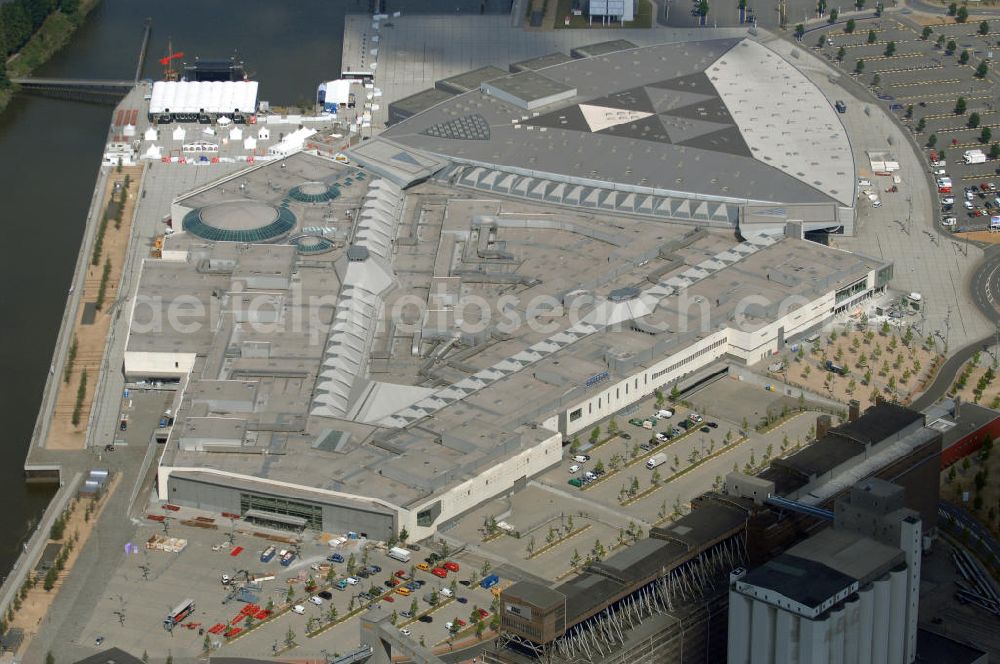 Aerial image BREMEN - Areal des Space Parks Bremen. Das Projekt wurde Anfang der 1990er Jahre von der in Wiesbaden ansässigen, inzwischen nicht mehr existenten Köllmann AG zusammen mit dem noch nicht realisierten Ocean Park in Bremerhaven geplant. Der Kerngedanke ist dabei die für Urban Entertainment Center typische Verbindung von Unterhaltung und Einzelhandel. Das Projekt wurde mit Unterstützung des Landes Bremen in Form von Subventionen unter Bauherrenschaft der zur Dresdner Bank gehörenden DEGI realisiert. Der Bau wurde im Juli 2000 begonnen und war am 19. Dezember 2003 fertig gestellt. Eröffnet wurde der Park am 12. Februar 2004.Der Space Park wurde an die britische Finanzinvestorengruppe „Cardinal Asset Management“ verkauft. Diese erklärte von Beginn an, den Space Park nicht selbst betreiben zu wollen, und verkaufte ihn schließlich für 50 Millionen Euro an den irischen Finanzdienstleister LNC Property Group. Im Februar 2007 kündigte der LNC-Chef Bill McCabe an, dass die LNC weitere 80 bis 100 Millionen Euro investieren wolle, um das Areal baulich zur Weser hin auszurichten und den Einzelhandelsbereich des Space Parks unter dem Namen „Waterfront Bremen“ im September 2008 wiederzueröffnen. Bis 2009 soll ein Sport-, Freizeit- und Wellnessbereich hinzukommen. Kalkuliert ist ein Einzugsgebiet mit einem Durchmesser von 200 Kilometern und eine Besucherzahl von im Durchschnitt täglich 25.000 Besuchern. Im Frühjahr 2007 wurde das Space Park Logo entfernt. Seit Anfang August hängt der Name Waterfront am Eingang. Limetree GmbH, AG-Weser-Straße 3 , 28237 Bremen,Telefon: +49 4213305 300;