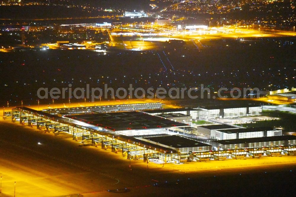 Schönefeld at night from the bird perspective: Night lighting Dispatch building and terminals on the premises of the airport BER in Schoenefeld in the state Brandenburg