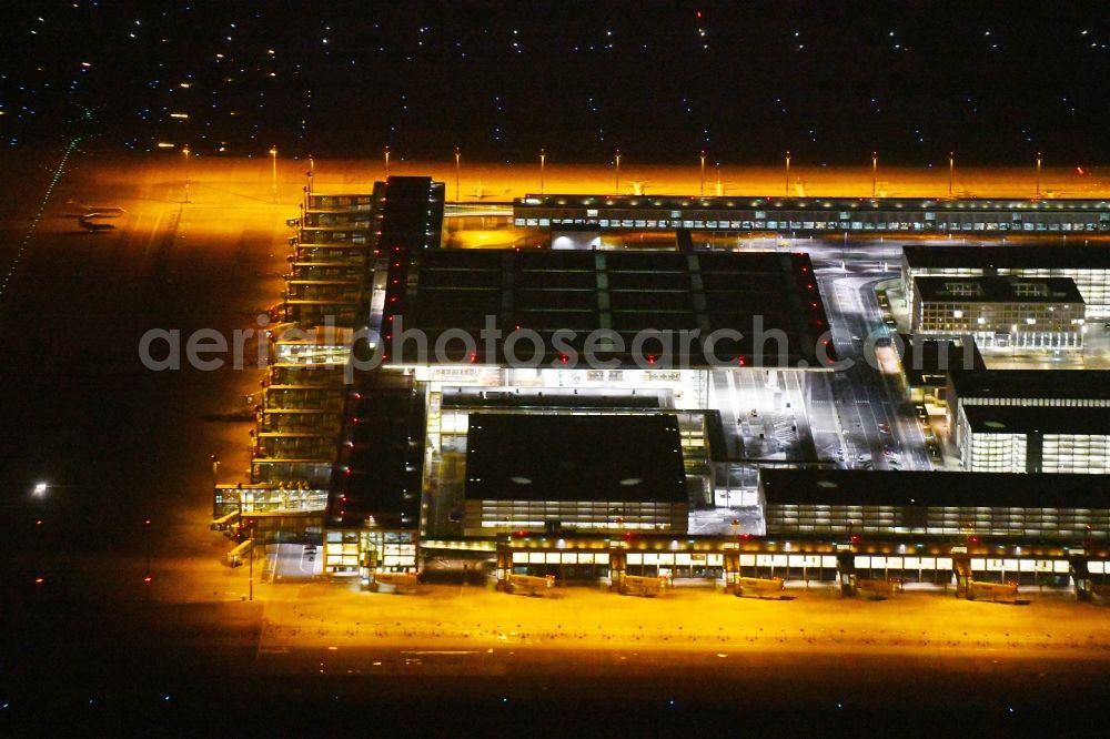 Schönefeld at night from the bird perspective: Night lighting Dispatch building and terminals on the premises of the airport BER in Schoenefeld in the state Brandenburg