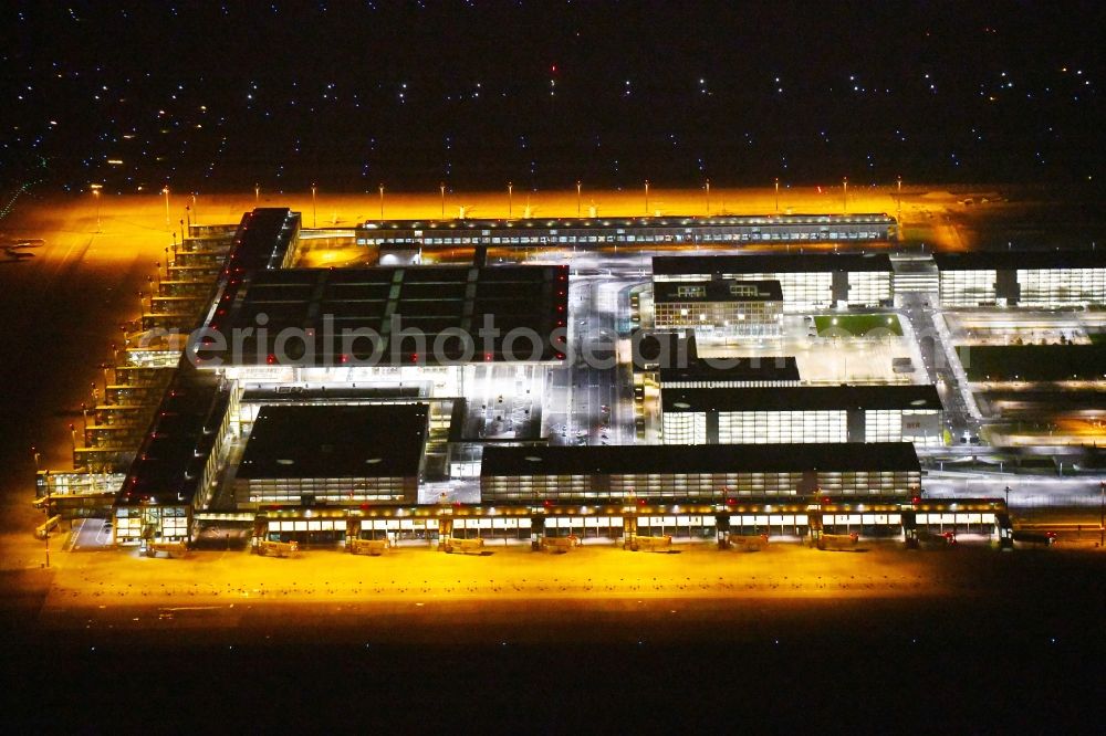 Aerial photograph at night Schönefeld - Night lighting Dispatch building and terminals on the premises of the airport BER in Schoenefeld in the state Brandenburg