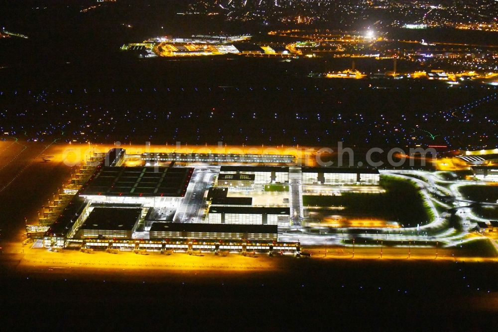 Aerial image at night Schönefeld - Night lighting Dispatch building and terminals on the premises of the airport BER in Schoenefeld in the state Brandenburg