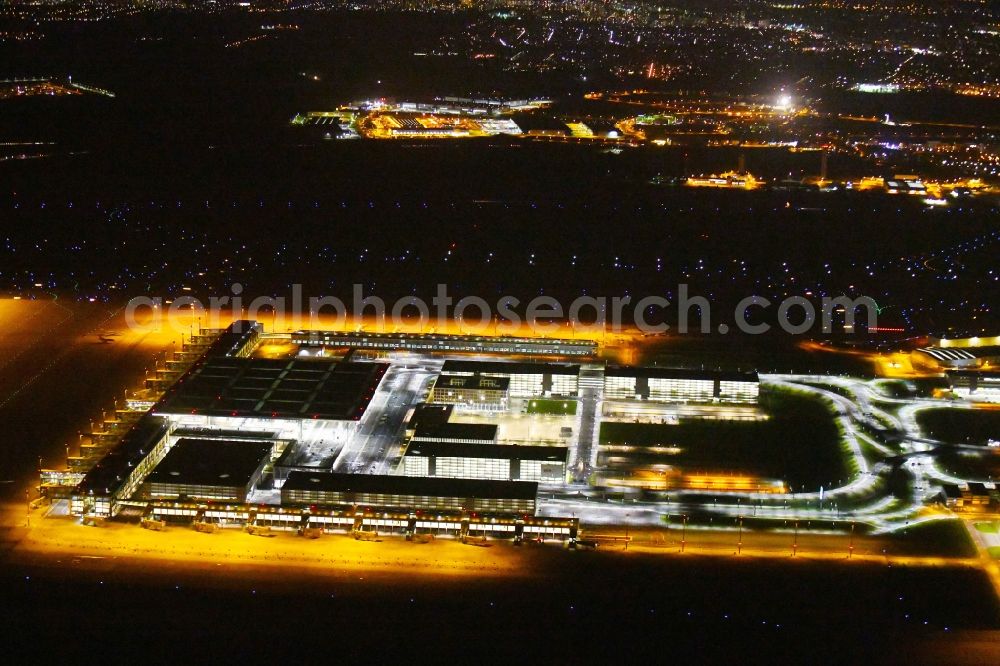 Schönefeld at night from the bird perspective: Night lighting Dispatch building and terminals on the premises of the airport BER in Schoenefeld in the state Brandenburg