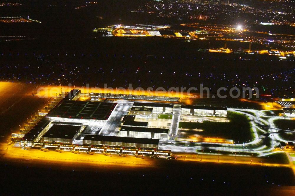 Aerial photograph at night Schönefeld - Night lighting Dispatch building and terminals on the premises of the airport BER in Schoenefeld in the state Brandenburg