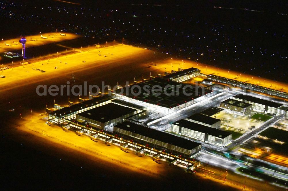 Schönefeld at night from the bird perspective: Night lighting Dispatch building and terminals on the premises of the airport BER in Schoenefeld in the state Brandenburg