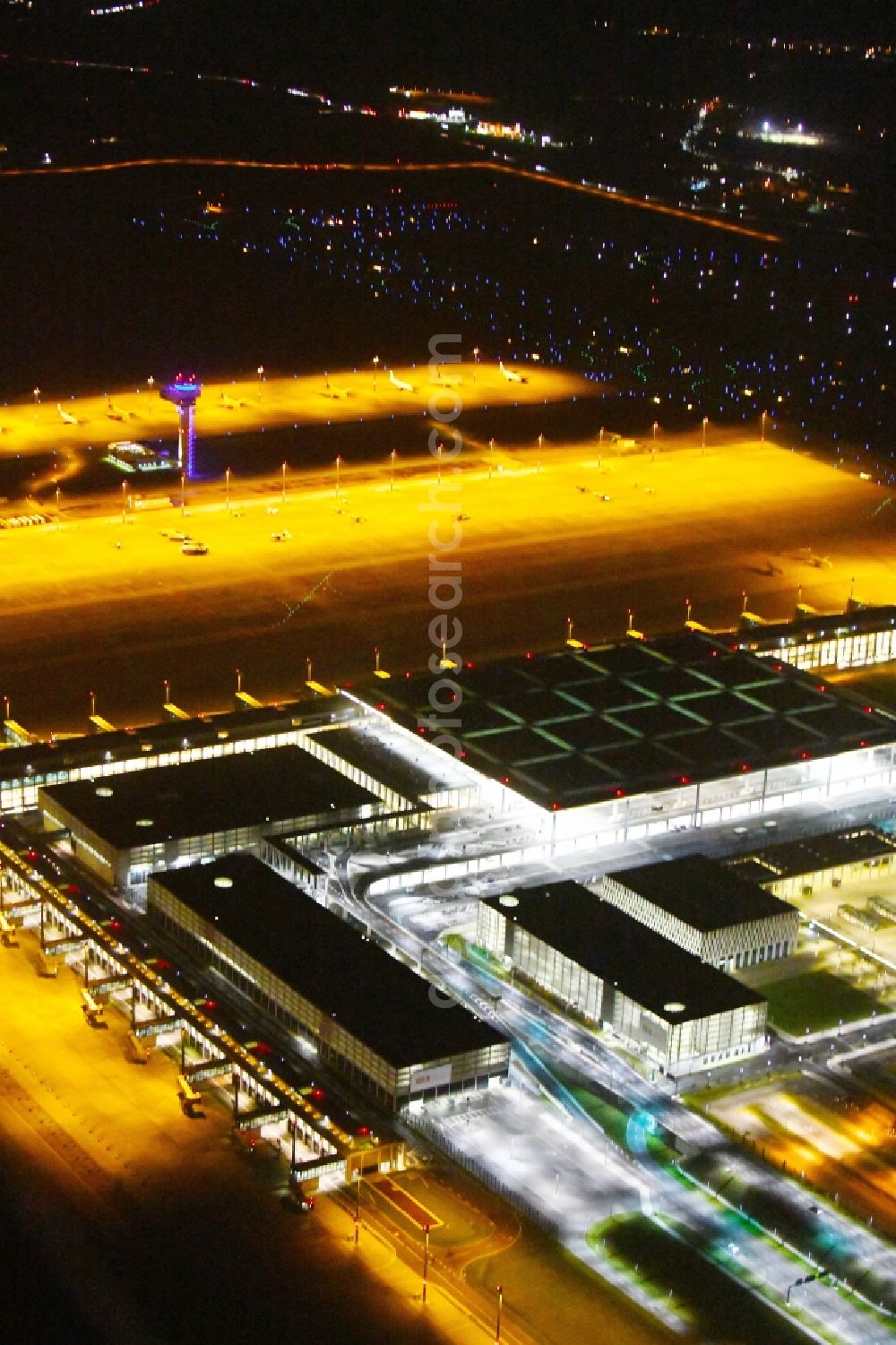 Aerial photograph at night Schönefeld - Night lighting Dispatch building and terminals on the premises of the airport BER in Schoenefeld in the state Brandenburg